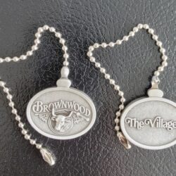 Two silver oval medallions: Brownwood and The Villages