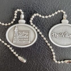 Two oval The Villages metal pull-chain tags