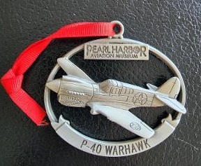 A silver ornament of a P-40 Warhawk airplane.